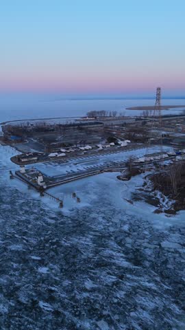 Aerial of the frozen Fox River and Green Bay Wisconsin at Dusk.  Orbital drone of Marina and Industry.