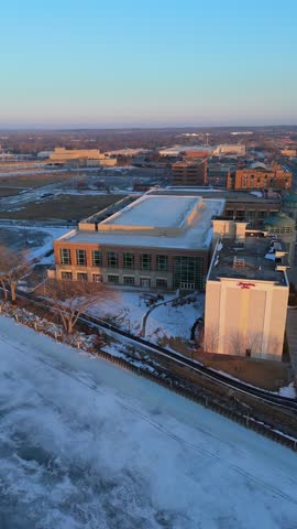 Aerial of the frozen Fox River and Green Bay Wisconsin at Dusk.  Orbital of downtown area.