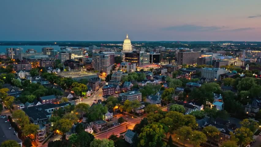 Aerial view of Madison skyline at dusk, with the illuminated Capitol Building standing out against the fading light over the cityscape.