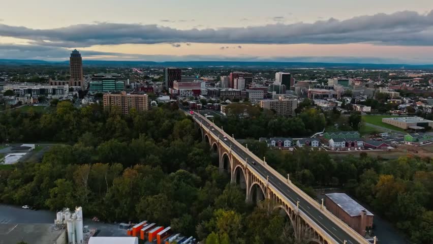 Aerial view of Allentown with urban buildings and streets, featuring a prominent bridge in the foreground under clear daylight.