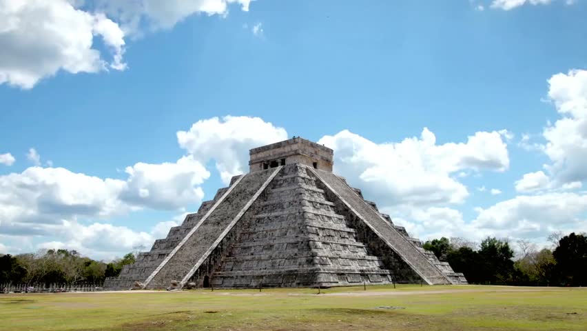 Chichen Itza pyramid in Mexico under a bright blue sky with white clouds, showcasing ancient architecture, history, and iconic Mayan heritage.