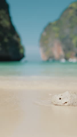 Rest in paradise in summer, unique seaview with famous thai Phi Phi Archipelago, calmness and solitude. Cinematic vertical shot from sandy beach in Maya Bay, visit Thailand and feel happiness and joy