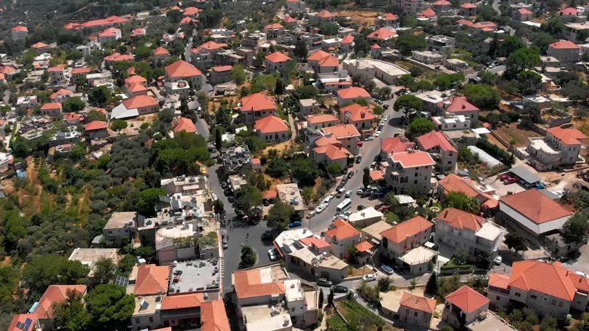 Establishing aerial drone footage of Douma, Lebanon, showcasing mountain village rooftops and greenery for tourism and lifestyle marketing.