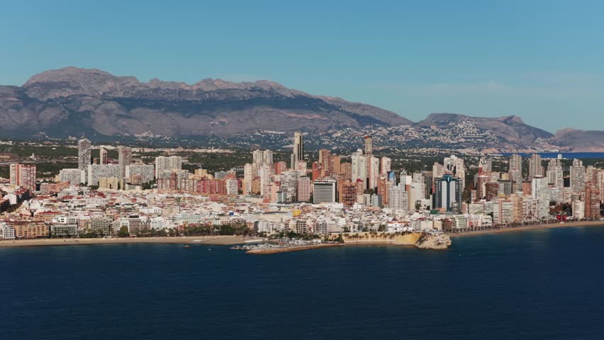 Drone view of the famous Benidorm skyline with its high rise buildings, hotels, and beach on the Mediterranean coast in Spain. Aerial lateral view, copy space