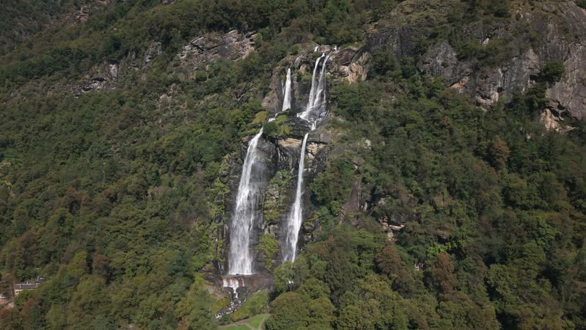 Powerful Acquafraggia waterfalls cascading down a mountain cliff in the Italian Alps in Piuro, Italy. Aerial drone lateral view