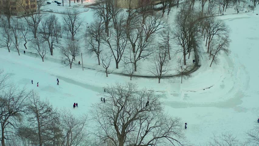 drone overlooking lake inside parc lafontaine in montreal quebec canada n people patin in winter