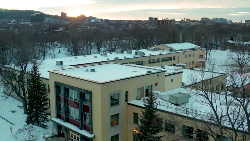 drone overlooking main front building in parc lafontaine, montreal, quebec, canada in winter n some long sunset
