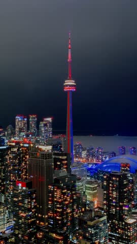 Vertical Toronto Hyperlapse at night as the CN Tower illuminates red and the city