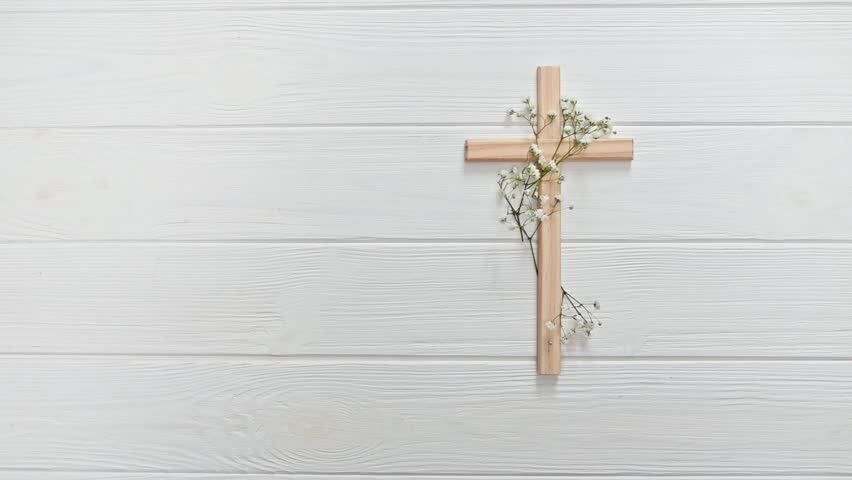 Christian wooden cross adorned with delicate white baby