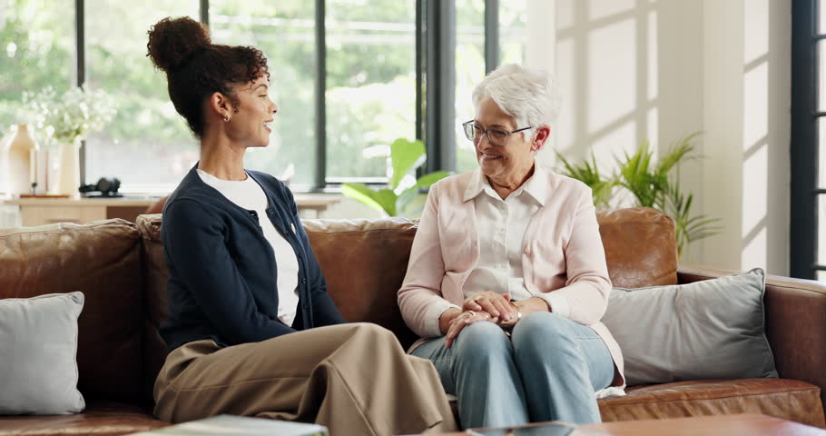 Healthcare, support or wellness with nurse and old woman on sofa in home for feedback or review. Conversation, medical or visit with caregiver and senior patient in apartment for assisted living
