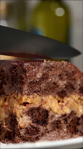 Fresh slice of chocolate cake rotating slowly on a white ceramic plate. The rotation reveals the rich chocolate layers, creamy frosting, and moist texture. Perfect for dessert advertising, bakery content, and food videos.