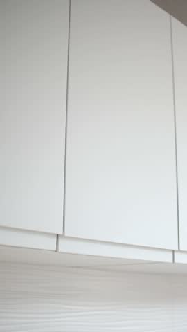 Woman opening almost empty pantry, food shortage and inflation concept