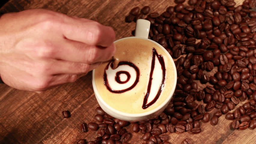 Professional barista painting a cup of cappuccino