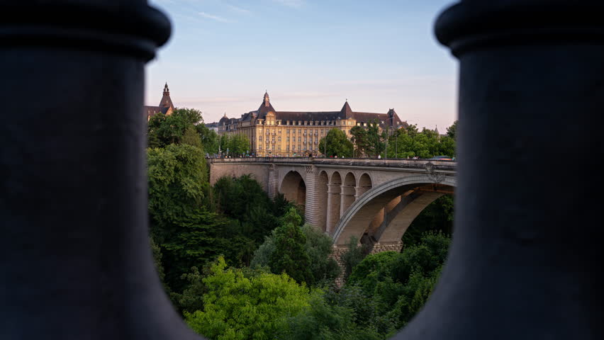 Timelapse clip of the Adolphe Bridge in Luxembourg City with the old historical buildings behind. The bridge was finished in 1903 and named after the Grand Duke Adolphe. Seen in the blue hour.