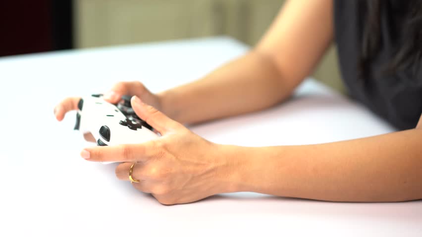 Steady Shot of Woman Gamer Holding Controller on Table During Gameplay