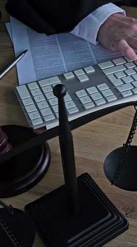 Law office setup shows tools of the trade with keyboard, gavel, and legal documents on a desk during the workday