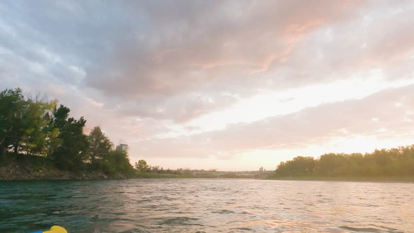 Stunning front view of a calm lake with majestic mountains rising in the background under a clear blue sky. The still water reflects the mountain peaks like a mirror, creating a peaceful and breathtak