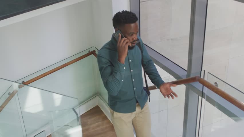 Animation of people icons over african american businessman talking on smartphone. Global business and digital interface concept digitally generated video.