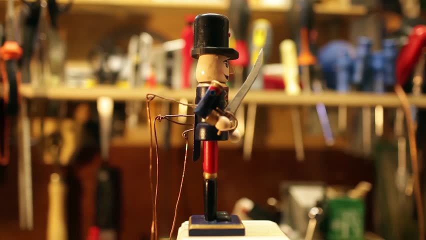 An antique wooden soldier puppet, wearing a colorful uniform, black cap, and carrying a saber. Workshop performance, loop