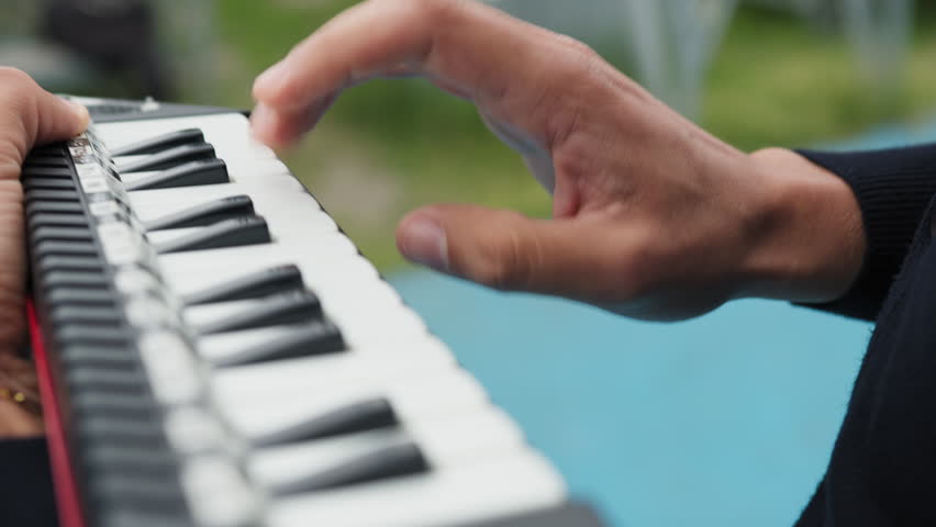 Man plays button melodica music instrument outside