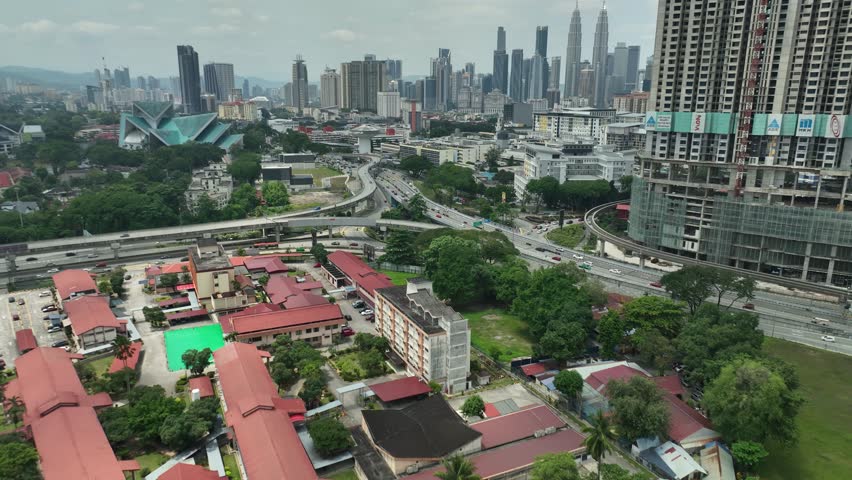 The urban landscape of Titiwangsa Kuala Lumpur is a dynamic scene of constant motion with cars and trains navigating a complex highway network, showcasing the city