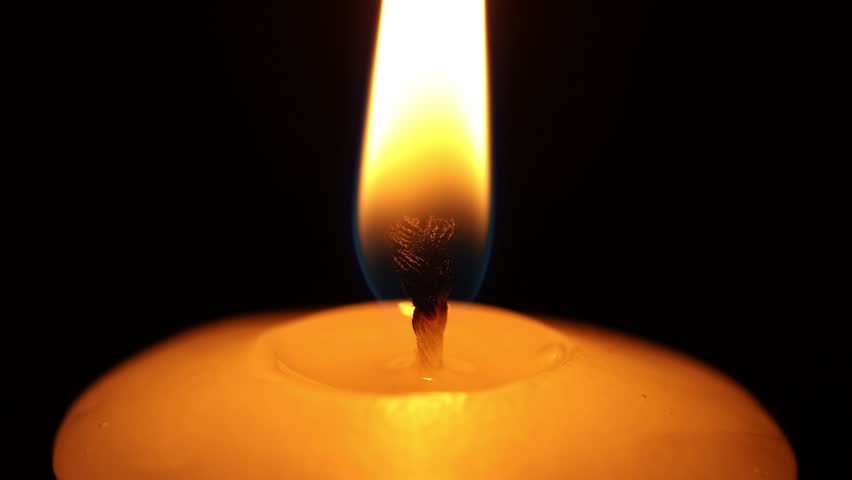 One burning candle on black background, closeup