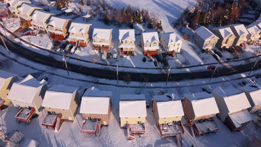 Top view of snow-covered neighborhood in Beechville, Halifax after heavy night snow. Roofs, yards and roads white in Nova Scotia winter daylight, Canada, typical post-storm suburban scene 4K.