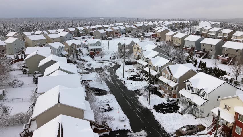 High drone perspective: private houses and neighborhood streets in Beechville covered with thick snow after night snowfall. Sunny Canadian winter in Nova Scotia, Halifax region, clean white landscape