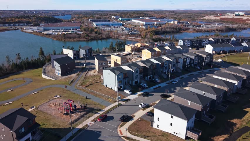 Aerial drone shot summer sunset: construction of high-end wooden frame homes in Beachville near Halifax. Nova Scotia Canada residential boom, warm golden hour illuminates new luxury builds 4K.