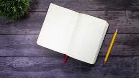 Top view of open blank notebook with pencil and plant on dark wooden table - Powered by Shutterstock - Get 15% off with code: PIKWIZARD15