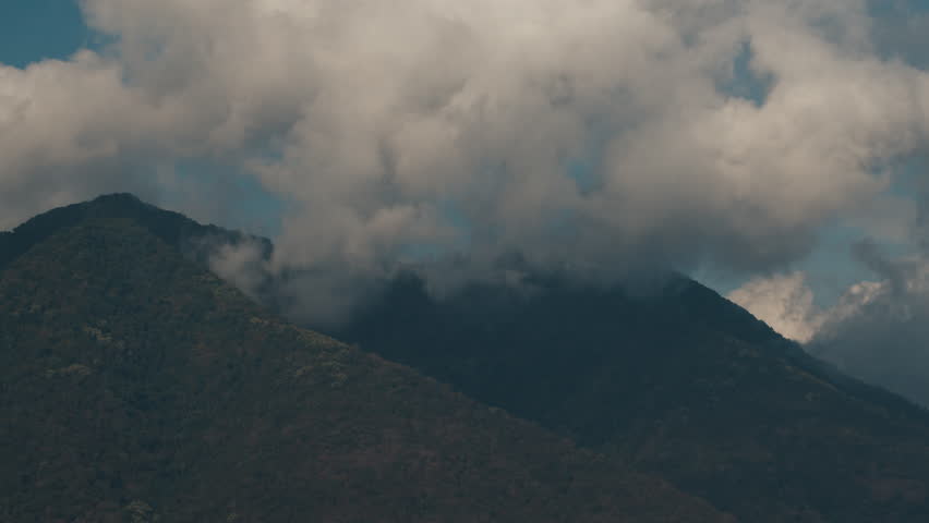 Timelapse of the clouds forming over the mountain covered with tropical forest. Indonesia