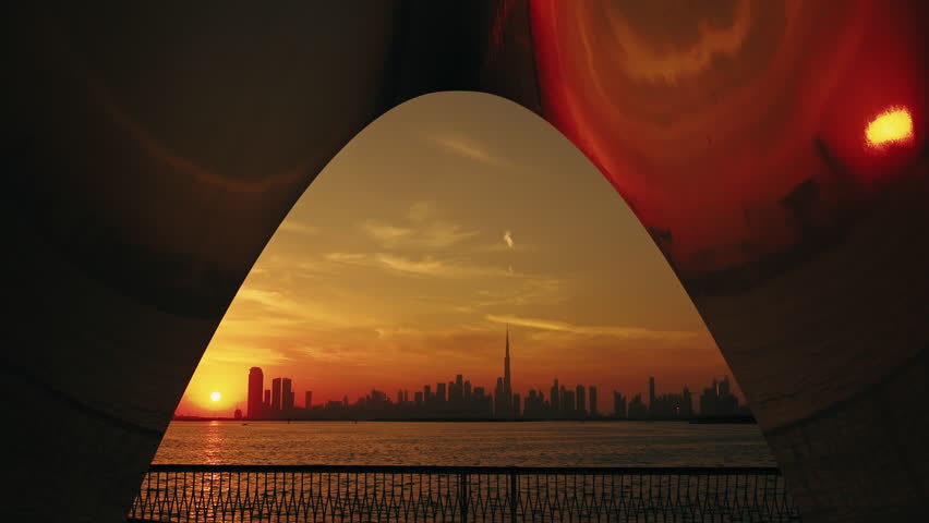 Spot to enjoy the Dubai city skyline at sunset, contemporary urban design, architecture, and a tranquil waterway, view from Creek Harbor.