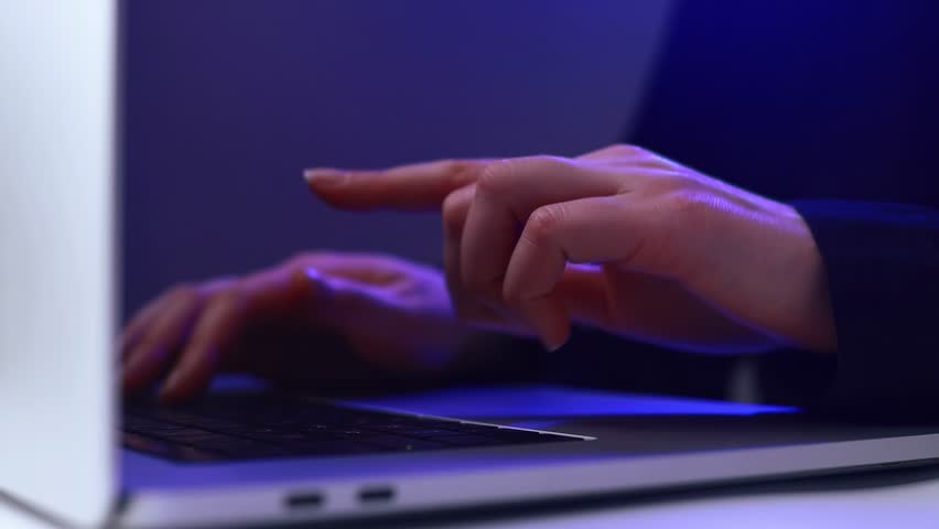 Hands typing on a laptop with a digital robot icon displayed on the screen while designing an AI prompt for various tasks.