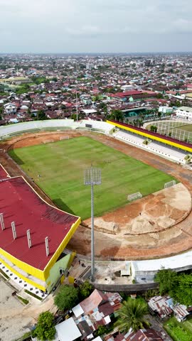 This shows the Stadion 17 Mei in Banjarmasin with a view of the field and nearby buildings