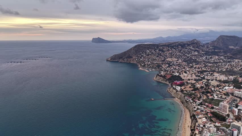 Aerial Coastal Town At Dusk, Sweeping Drone Reveal Of Curved Beach, Turquoise Shallows, Clustered RedRoof