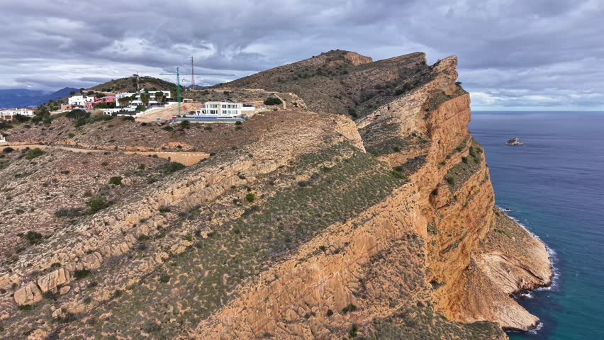 Dramatic Cliffside Lookout With Rocky Outcrop And Perched Buildings, Steep Precipice Dropping To Blue Sea,