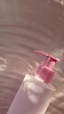 High-angle shot of a blank pink cosmetic bottle with a pump dispenser lying on a beige surface with soft shadows. Minimalist beauty product mockup. - Powered by Shutterstock - Get 15% off with code: PIKWIZARD15