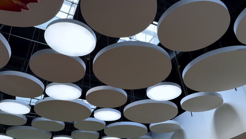 Unusual design elements on the ceiling of the room. Low angle view. Light and decor in the interior.