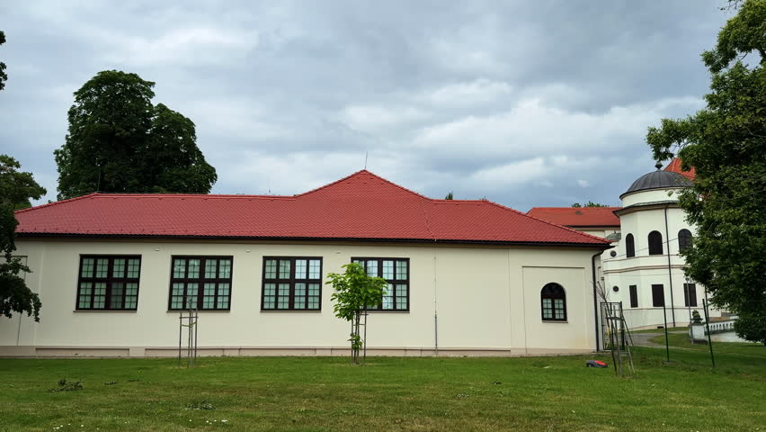 One-storied building with a red roof. Ensemble of a historical buildings in the nature surrounding.