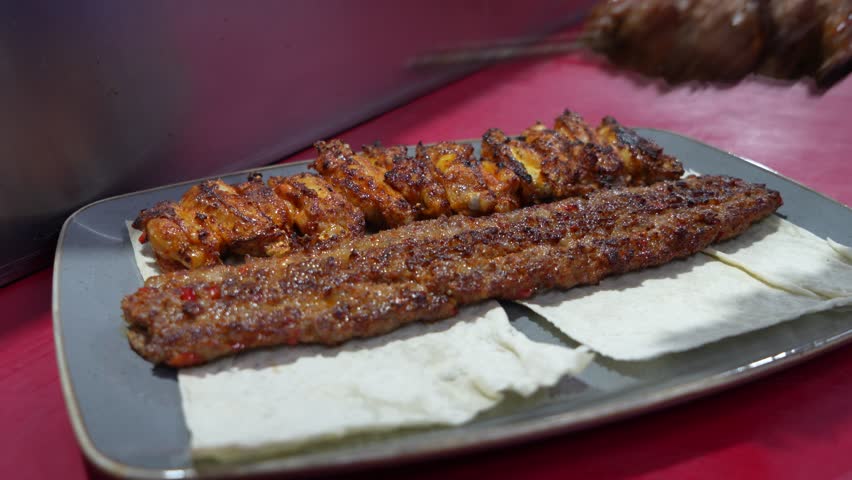 A video showing the preparation of traditional Turkish kebab. The video shows Turkish food being cooked, specifically Adana kebab portions.