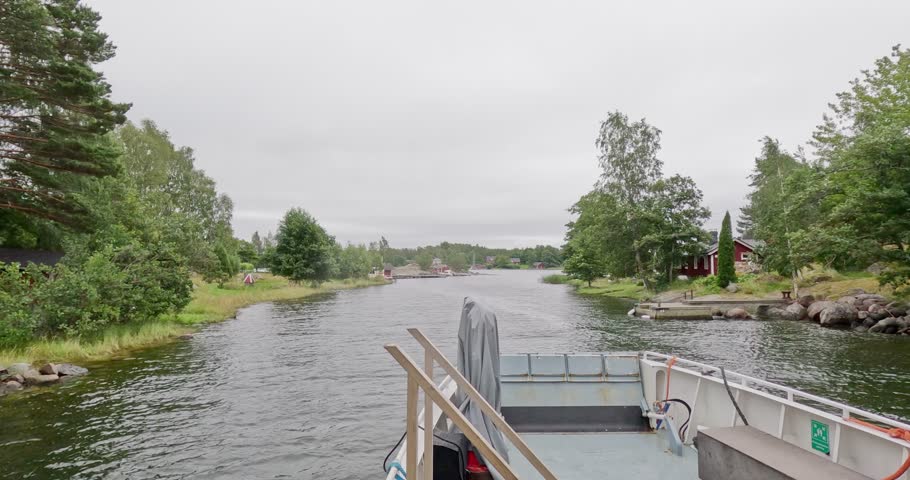 Passenger ferry going through narrow Fagersundet strait on a cloudy summer day, Pirttisaari, Finland, Europe.