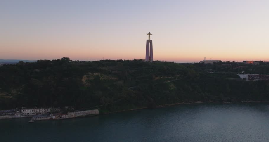 Cristo rei Christ statue in Lisbon, Portugal. Sunset, dusk, side-on aerial shot