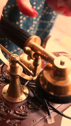 Close up of a hand picking up the receiver of a vintage corded telephone, illustrating retro communication, ringing phone, and nostalgic office or home concept with classic design