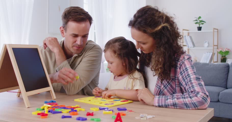 Family parents and daughter play at home at table. They guide child and girl with educational game using numbers and shapes, boosting education together. Family learning and bonding concept.