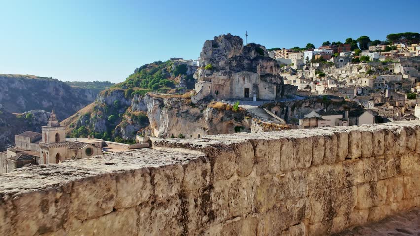 Matera old town in Basilicata, Italy. Prehistoric Sassi cave dwellings carved into limestone, creating a stunning landscape in one of the oldest cities in the world. Cinematic slow motion reveal