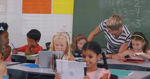 A teacher teaching kids on a digital tablet in a classroom at school. Education learning and technology concept digitally generated video. - Powered by Shutterstock - Get 15% off with code: PIKWIZARD15