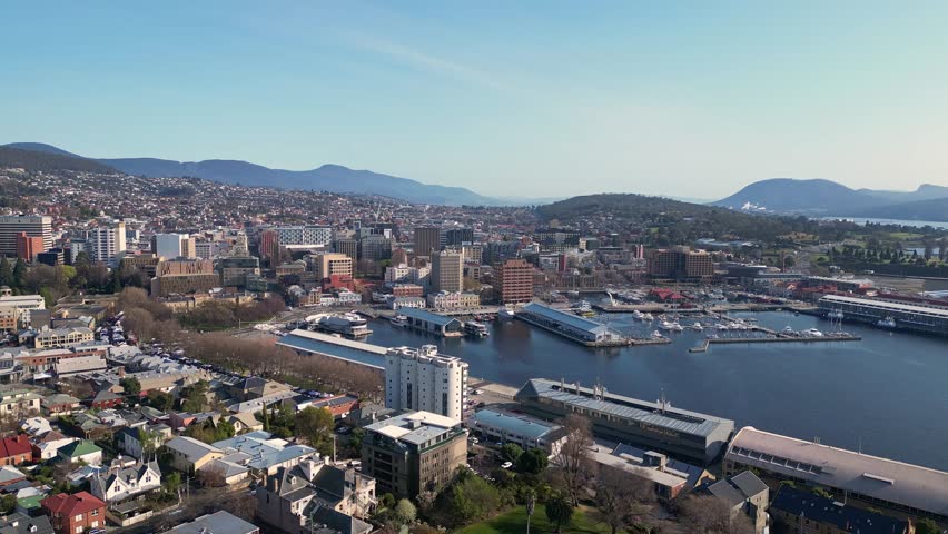 Hobart, Australia: Aerial drone footage of a boat that leaves the main harbor in Hobart by the central business district in Tasmania main city on a sunny day in Australia
