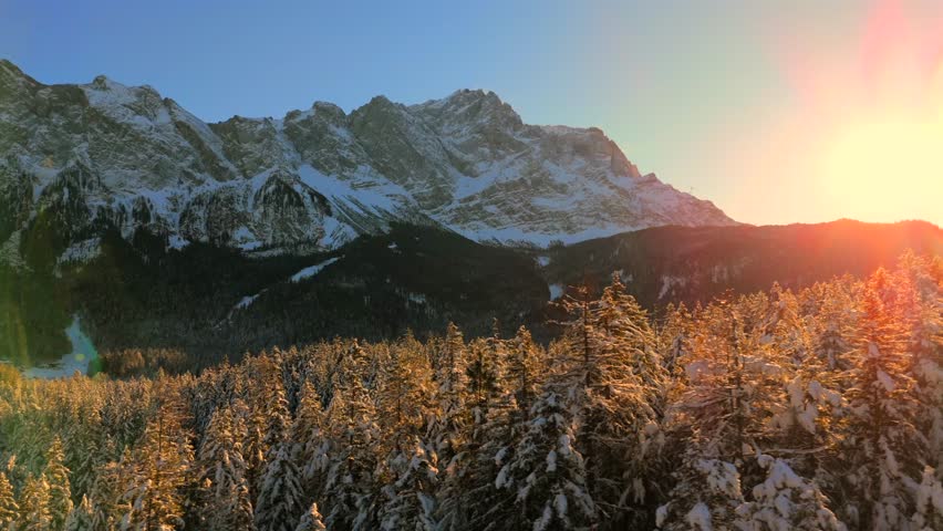 Breathtaking aerial view over snow-covered treetops in Germanys Bavarian Alps, showcasing Zugspitze massif. Zugspitze Gipfel highest peak of Wetterstein Mountains and highest mountain in Germany. 