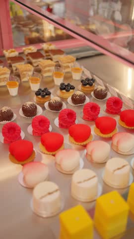 Colorful assortment of gourmet pastries and desserts in a bakery window. Sweet pastries concept.