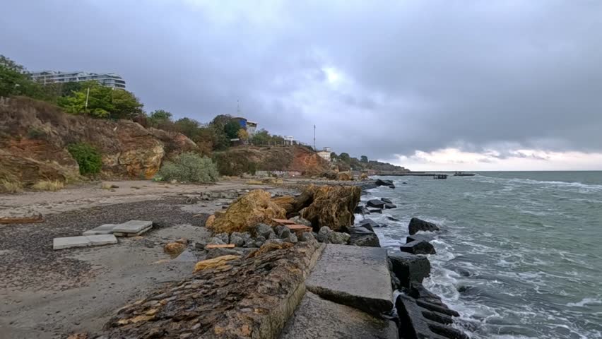 A small storm in the Black Sea near the rocky shore of Odessa under overcast conditions, Ukraine